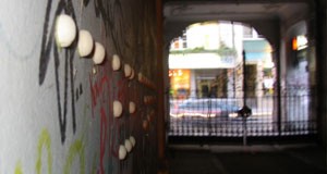 Large-scale braille dots in the wall of an alleyway