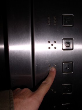 Lift buttons with tactile dots representing floor numbers.
